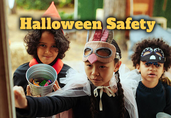 Three trick or treators at a door in costume with the text Halloween Safety.